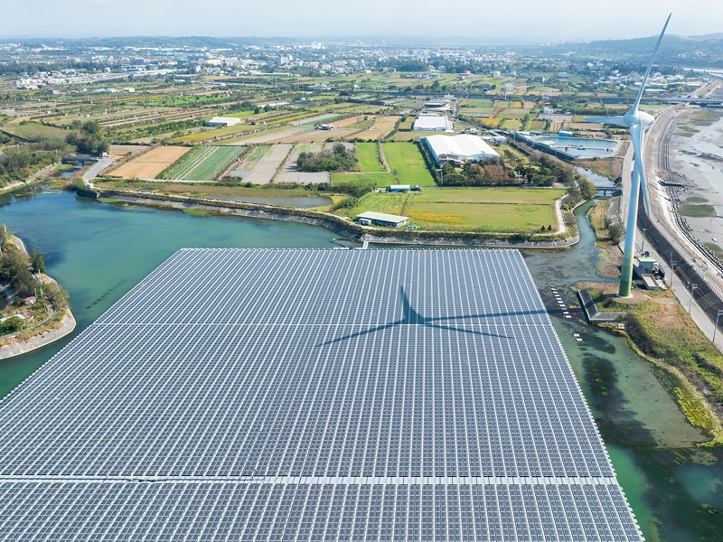 Luftbild von Flächenphotovoltaik und Windrad in ländlicher Umgebung